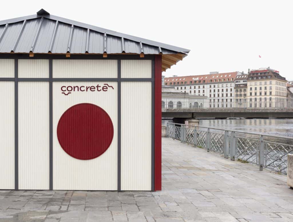 Façade d'une structure en béton avec logo rouge et texte 'concrete' à Genève.
